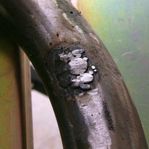 Bolt tack-welded into exhaust pipe to close up hole