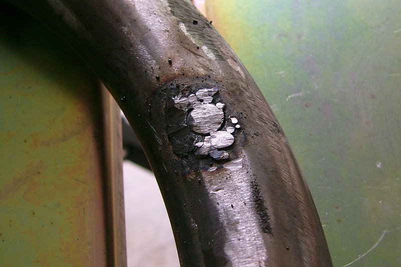 Bolt tack-welded into exhaust pipe to close up hole