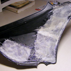 Fiberglass cloth and plastic bonder on back of cracked side cover